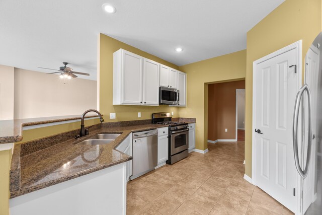 9032 Polaris Lakes Dr, Columbus, OH 43240 - kitchen featuring appliances with stainless steel finishes, a sink, dark stone counters, white cabinetry, and ceiling fan