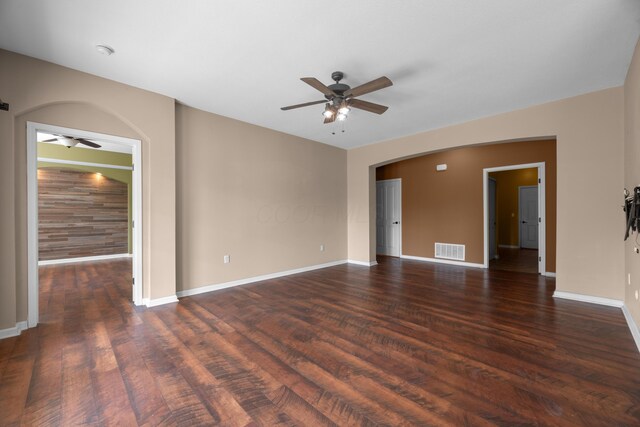 9032 Polaris Lakes Dr, Columbus, OH 43240 - spare room with a ceiling fan, arched walkways, dark wood-style flooring, and baseboards