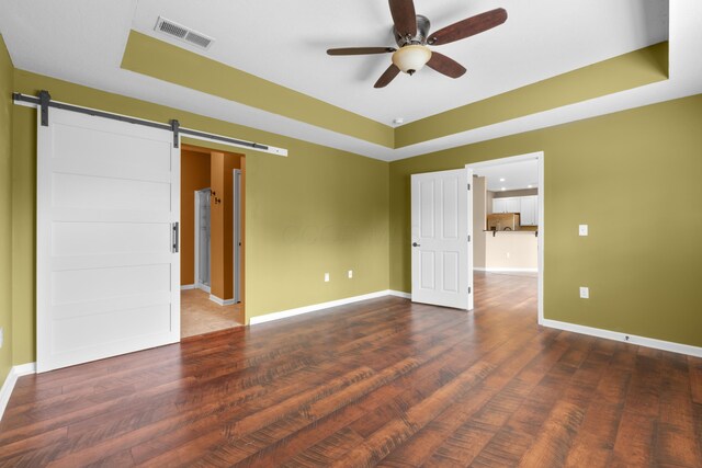 9032 Polaris Lakes Dr, Columbus, OH 43240 - empty room with ceiling fan, a tray ceiling, a barn door, and baseboards