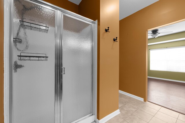 9032 Polaris Lakes Dr, Columbus, OH 43240 - bathroom with a stall shower, tile patterned flooring, ceiling fan, and baseboards
