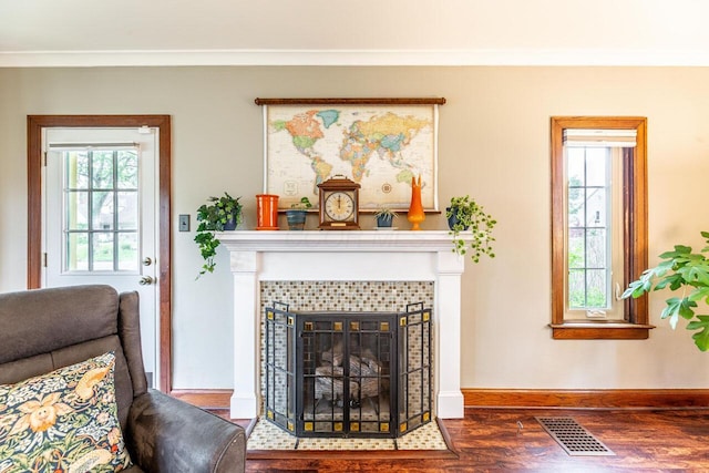 1674 Melrose Ave, Columbus, OH 43224 - living area with wood finished floors, a tile fireplace, baseboards, and crown molding