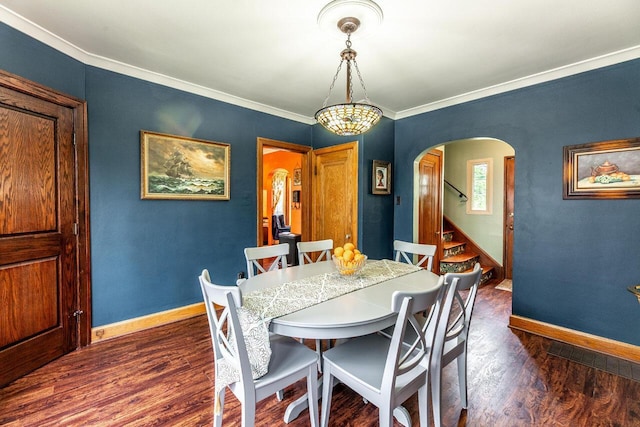 1674 Melrose Ave, Columbus, OH 43224 - dining space with arched walkways, baseboards, dark wood-style flooring, crown molding, and stairway