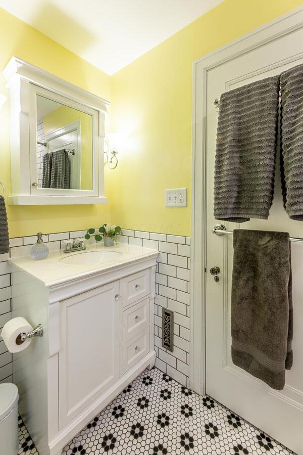 1674 Melrose Ave, Columbus, OH 43224 - bathroom with tile walls, vanity, tile patterned floors, and a wainscoted wall
