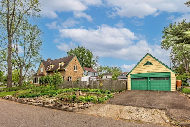 1674 Melrose Ave, Columbus, OH 43224 - view of side of home featuring a detached garage, fence, and a chimney