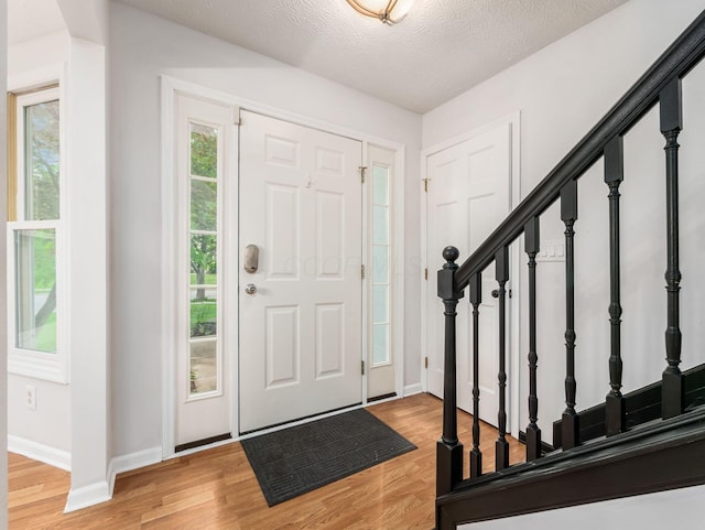 1249 Sea Shell Dr, Westerville, OH 43082 - entrance foyer with light wood-style floors, stairway, baseboards, and a textured ceiling