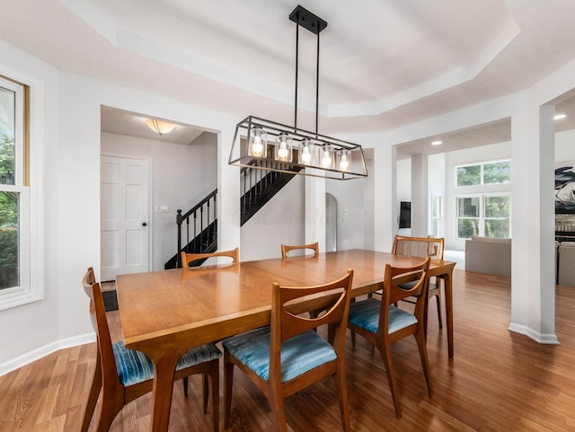 1249 Sea Shell Dr, Westerville, OH 43082 - dining space with a tray ceiling, stairs, wood finished floors, baseboards, and arched walkways