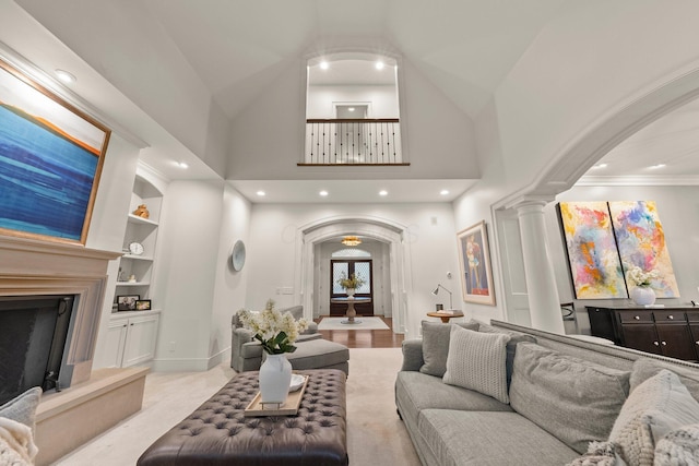 2060 Fontenay Pl, Upper Arlington, OH 43220 - living area with arched walkways, a fireplace with raised hearth, decorative columns, built in shelves, and high vaulted ceiling