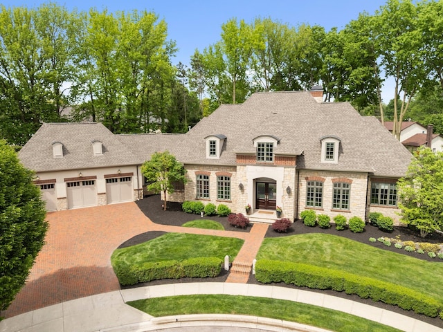 2060 Fontenay Pl, Upper Arlington, OH 43220 - french provincial home featuring stone siding, decorative driveway, a shingled roof, and a front yard