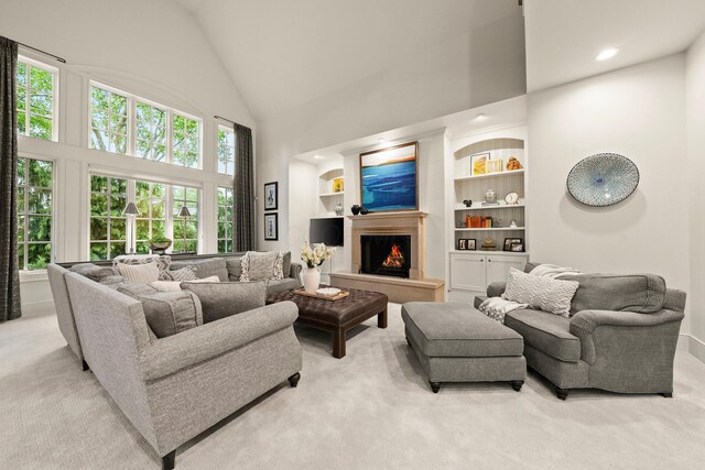 2060 Fontenay Pl, Upper Arlington, OH 43220 - living area with light colored carpet, high vaulted ceiling, a lit fireplace, built in shelves, and recessed lighting