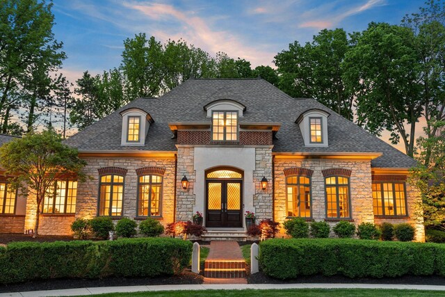 2060 Fontenay Pl, Upper Arlington, OH 43220 - view of front facade featuring stone siding, french doors, and roof with shingles
