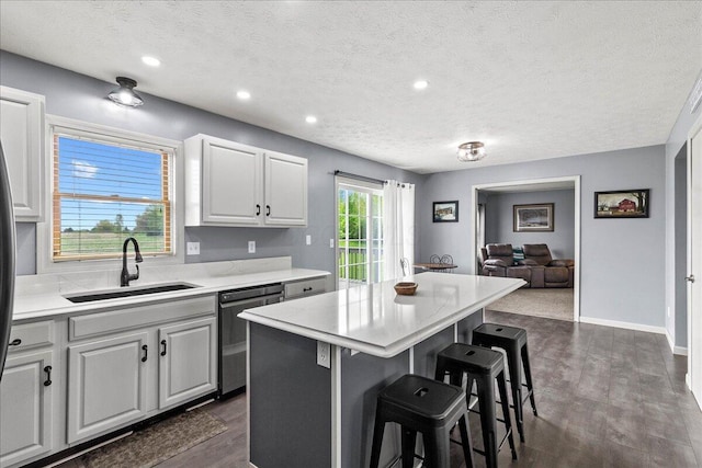 10746 State Route 287, Zanesfield, OH 43360 - kitchen featuring dishwashing machine, a sink, a kitchen breakfast bar, a textured ceiling, and light countertops