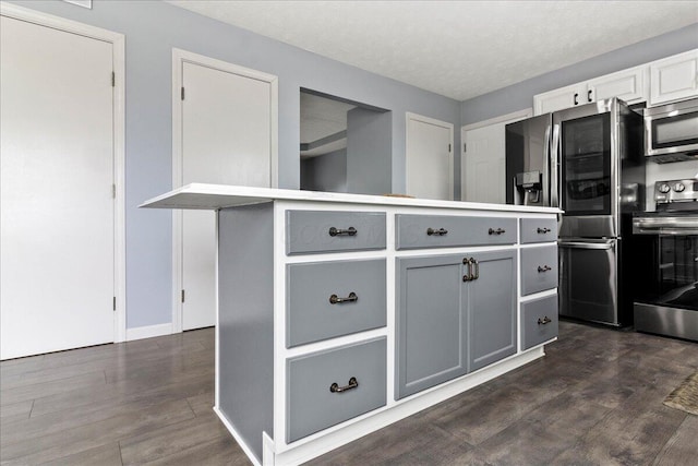 10746 State Route 287, Zanesfield, OH 43360 - kitchen featuring stainless steel appliances, gray cabinetry, dark wood-type flooring, baseboards, and a textured ceiling