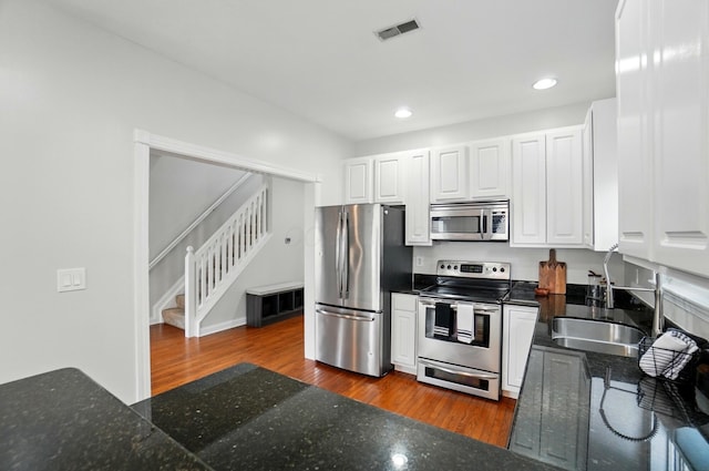 1077 Michigan Ave Unit 9, Columbus, OH 43201 - kitchen with stainless steel appliances, a sink, white cabinetry, dark wood-style floors, and recessed lighting