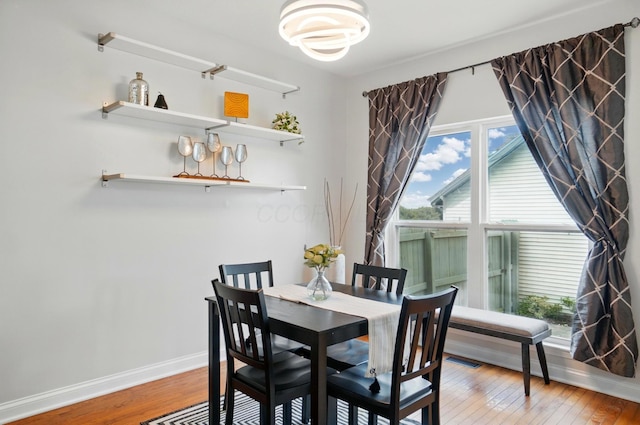 1077 Michigan Ave Unit 9, Columbus, OH 43201 - dining space featuring hardwood / wood-style flooring, baseboards, and a chandelier