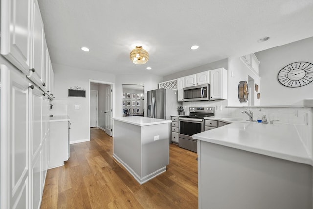 7257 Scioto Pkwy, Powell, OH 43065 - kitchen with stainless steel appliances, wood finished floors, tasteful backsplash, white cabinets, and recessed lighting