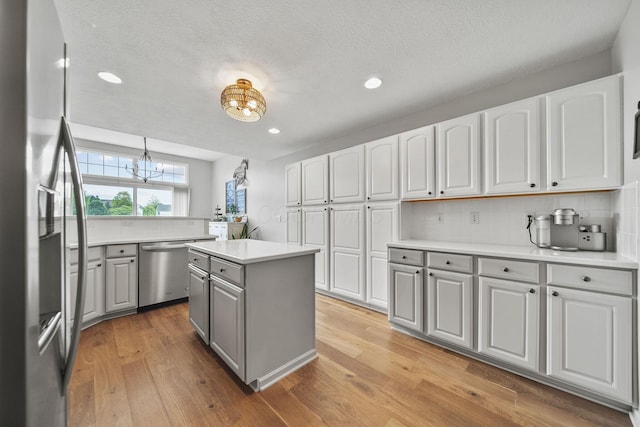 7257 Scioto Pkwy, Powell, OH 43065 - kitchen featuring gray cabinets, stainless steel appliances, decorative backsplash, light wood finished floors, and a chandelier