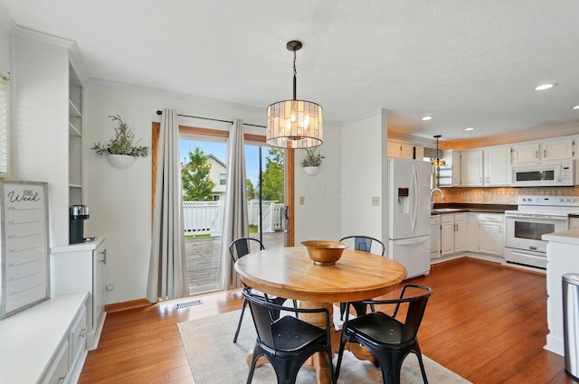 1407 Valley Dr, Marysville, OH 43040 - dining space with a chandelier, light wood-style flooring, recessed lighting, ornamental molding, and baseboards