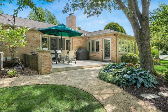 2790 Alliston Ct, Columbus, OH 43220 - back of property featuring brick siding, a chimney, a patio, cooling unit, and roof with shingles