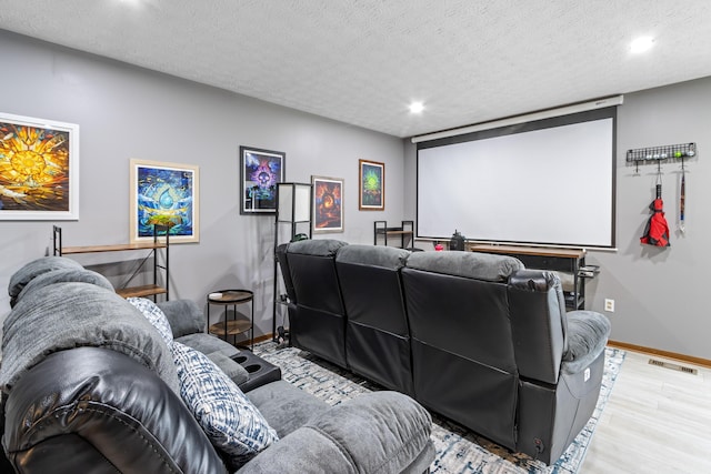 home theater featuring baseboards, wood finished floors, recessed lighting, and a textured ceiling