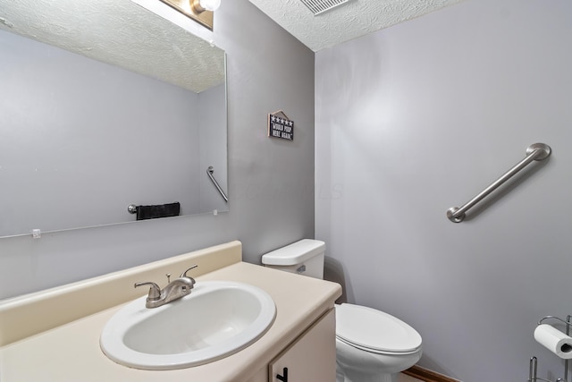 bathroom with toilet, a textured ceiling, and vanity