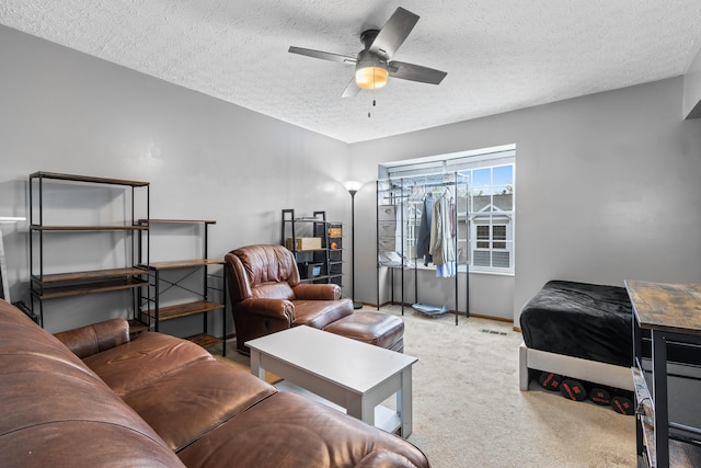 carpeted bedroom featuring a textured ceiling, a ceiling fan, and baseboards