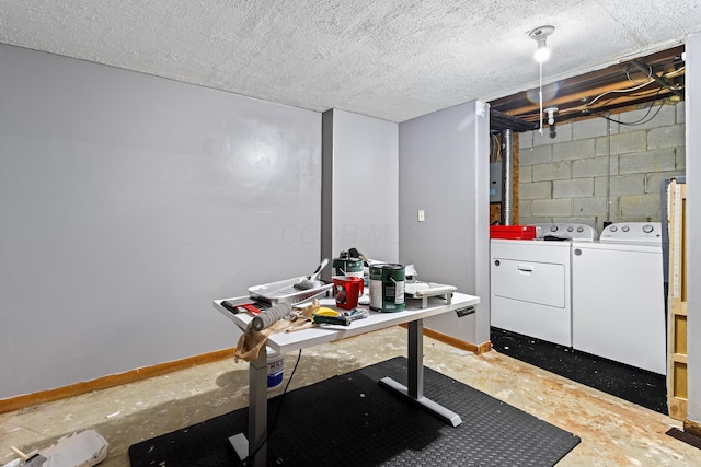 laundry room with washer and clothes dryer, concrete block wall, and baseboards