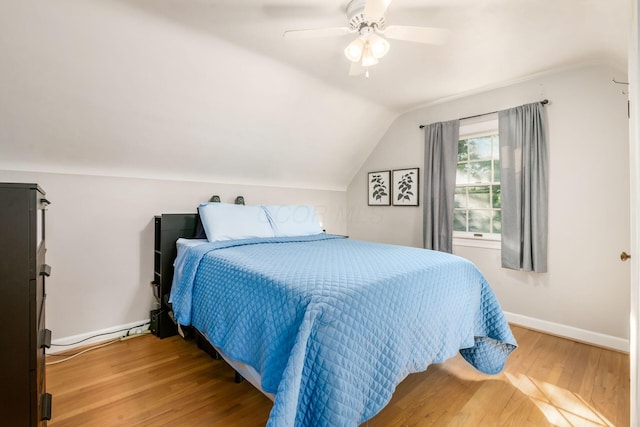 bedroom featuring vaulted ceiling, light wood-style flooring, a ceiling fan, and baseboards