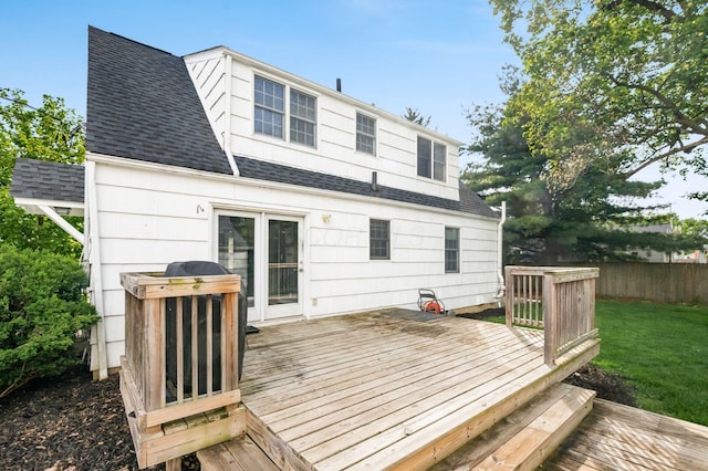 rear view of house featuring a shingled roof and a wooden deck
