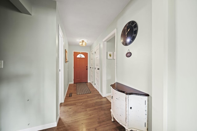 corridor with wood finished floors and baseboards