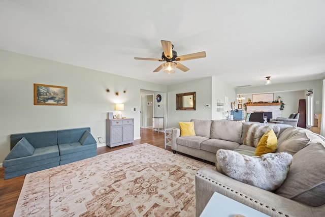 living area with dark wood-type flooring, ceiling fan, and baseboards