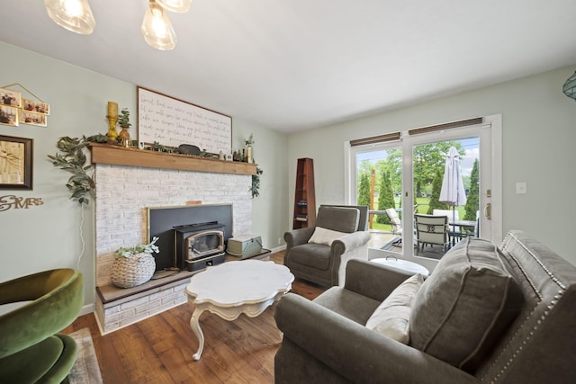 living room featuring a wood stove, wood finished floors, and baseboards