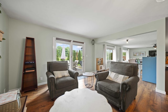 living room with wood finished floors, ceiling fan, and baseboards