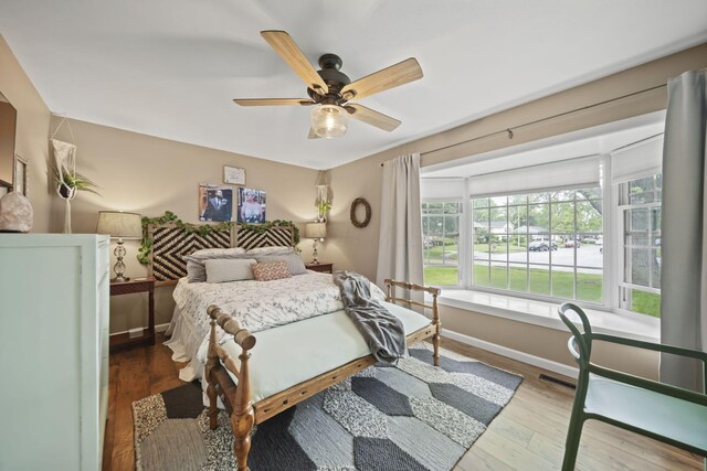 bedroom featuring hardwood / wood-style floors, ceiling fan, and baseboards