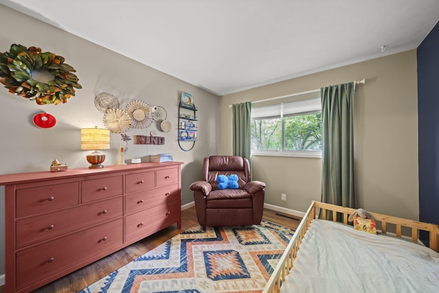 bedroom featuring wood finished floors and baseboards