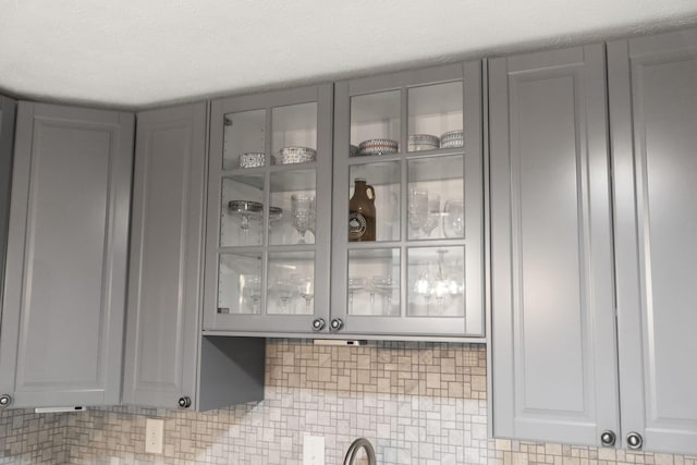 kitchen view of gray cabinets, french doors, and glass insert cabinets