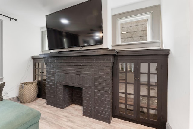 detailed view of wood finished floors and a brick fireplace