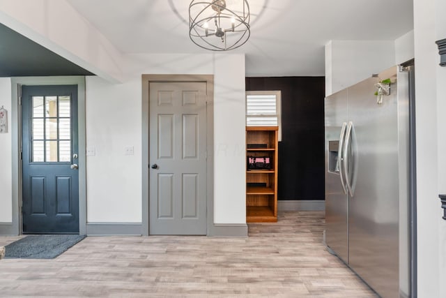 foyer entrance featuring light wood-style floors and a chandelier