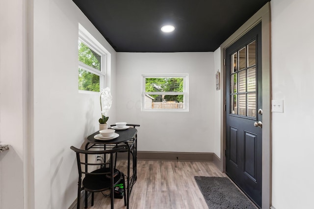 entryway with light wood-style floors, healthy amount of natural light, and baseboards
