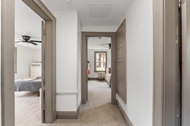 hallway with light colored carpet and baseboards