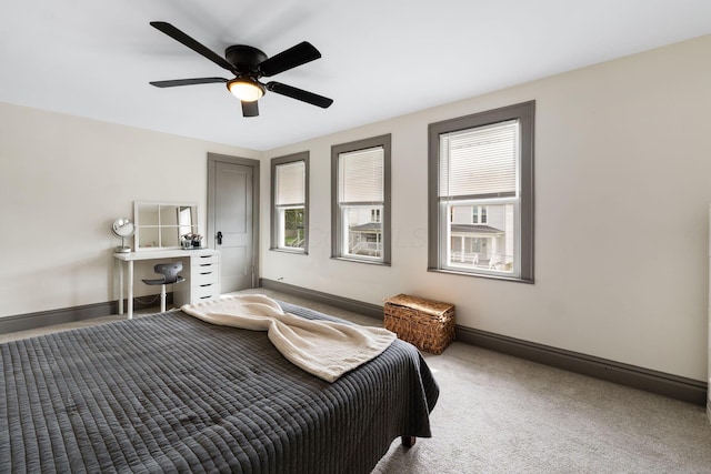 carpeted bedroom with multiple windows, baseboards, and a ceiling fan