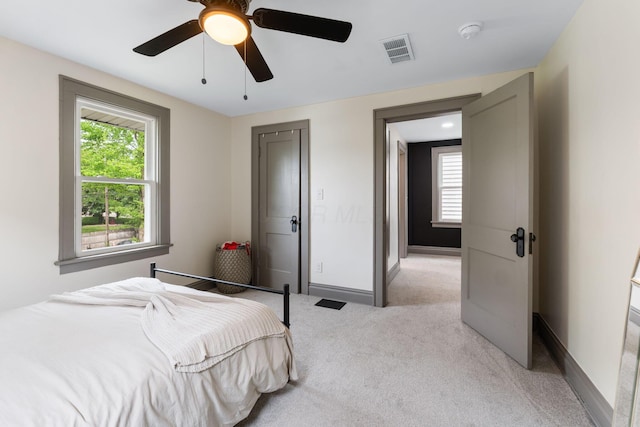 bedroom featuring light carpet, baseboards, and ceiling fan