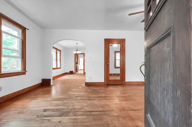 253 Robbins Dr, Newark, OH 43055 - unfurnished living room with arched walkways, light wood-type flooring, ceiling fan, and healthy amount of natural light
