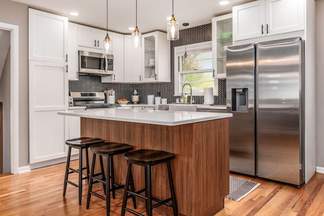 363 Cheyenne Dr, Westerville, OH 43081 - kitchen featuring stainless steel appliances, tasteful backsplash, white cabinets, glass insert cabinets, and light countertops