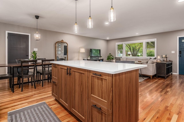 363 Cheyenne Dr, Westerville, OH 43081 - kitchen featuring light wood-type flooring, brown cabinets, light countertops, open floor plan, and pendant lighting