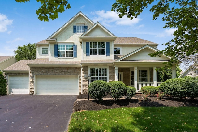 6923 Bishops Crossing Cir, Dublin, OH 43016 - view of front of property featuring driveway, a porch, stone siding, stucco siding, and an attached garage
