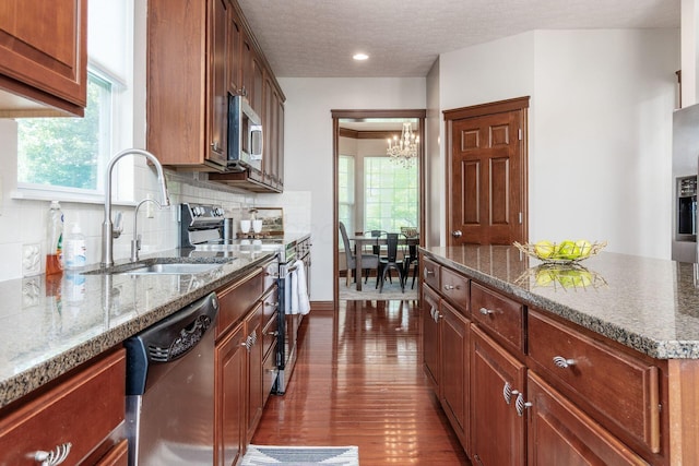6923 Bishops Crossing Cir, Dublin, OH 43016 - kitchen with appliances with stainless steel finishes, a chandelier, healthy amount of natural light, tasteful backsplash, and a textured ceiling