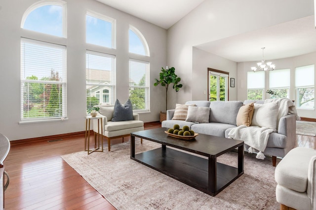 6923 Bishops Crossing Cir, Dublin, OH 43016 - living area featuring healthy amount of natural light, a chandelier, wood finished floors, and a high ceiling