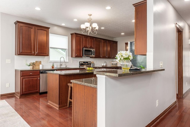 6923 Bishops Crossing Cir, Dublin, OH 43016 - kitchen with stainless steel appliances, recessed lighting, dark wood finished floors, tasteful backsplash, and dark stone countertops