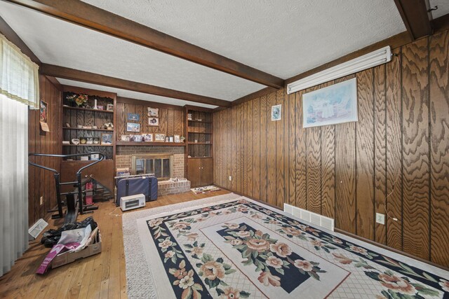 6329 Birkewood St, Columbus, OH 43229 - office area with hardwood / wood-style floors, wooden walls, beamed ceiling, a textured ceiling, and a brick fireplace