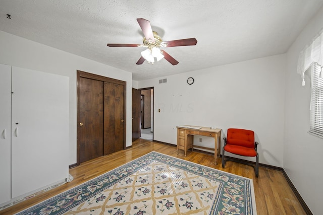 6329 Birkewood St, Columbus, OH 43229 - living area featuring light wood-type flooring, ceiling fan, baseboards, and a textured ceiling